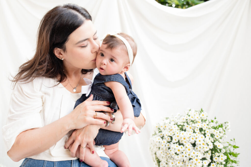 Fotografia - Amor de mãe: Michelle Loreto e Aurora em um abraço caloroso em fundo suave.